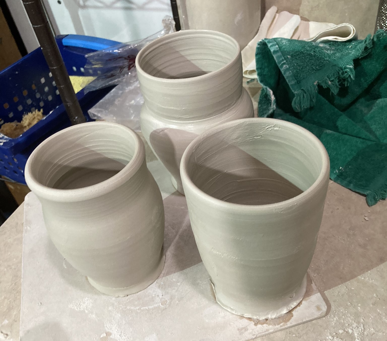Three thrown mugs recently taken off wheel